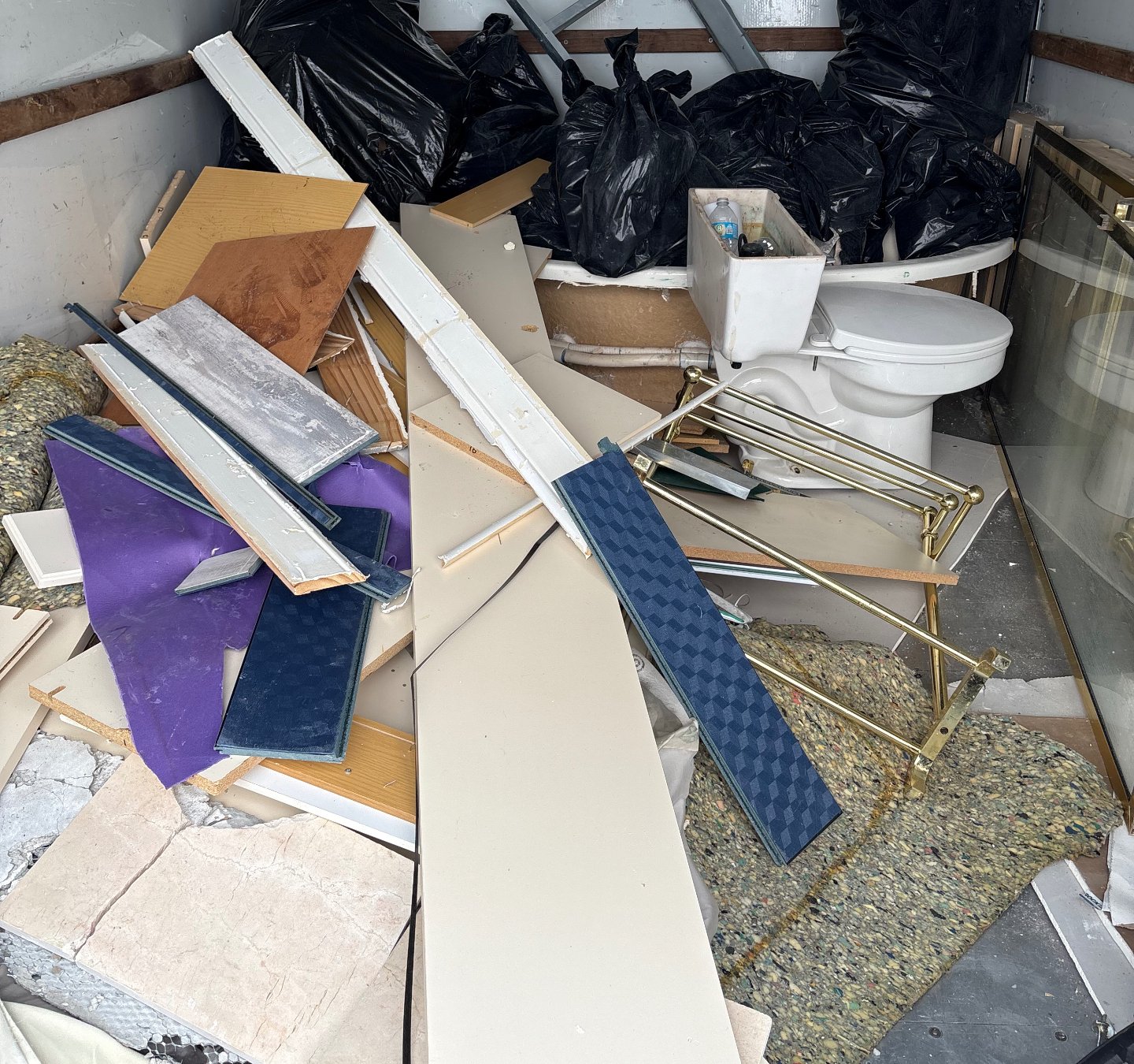 Removed bathroom fixtures and tear-out debris loaded for hauling